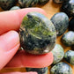 Lifestyle view of a Jade tumbled stone, sourced from Peru.