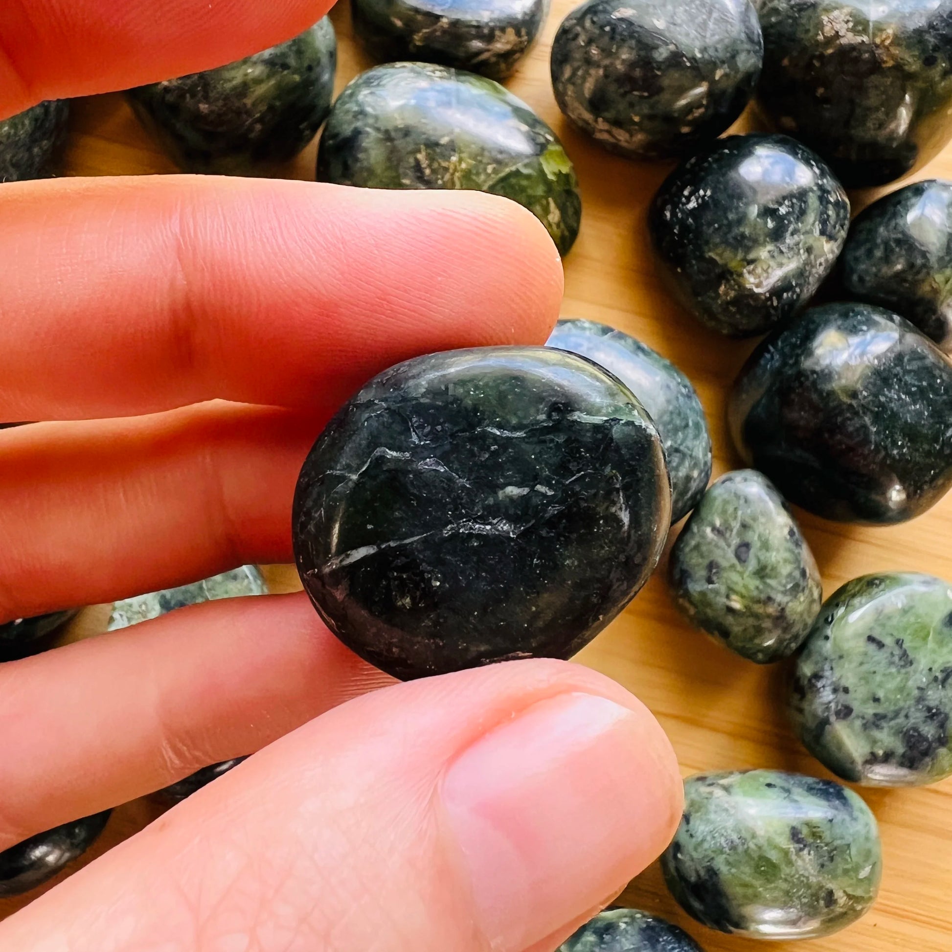 Detail shot of Grade A Jade tumbled stone under natural light