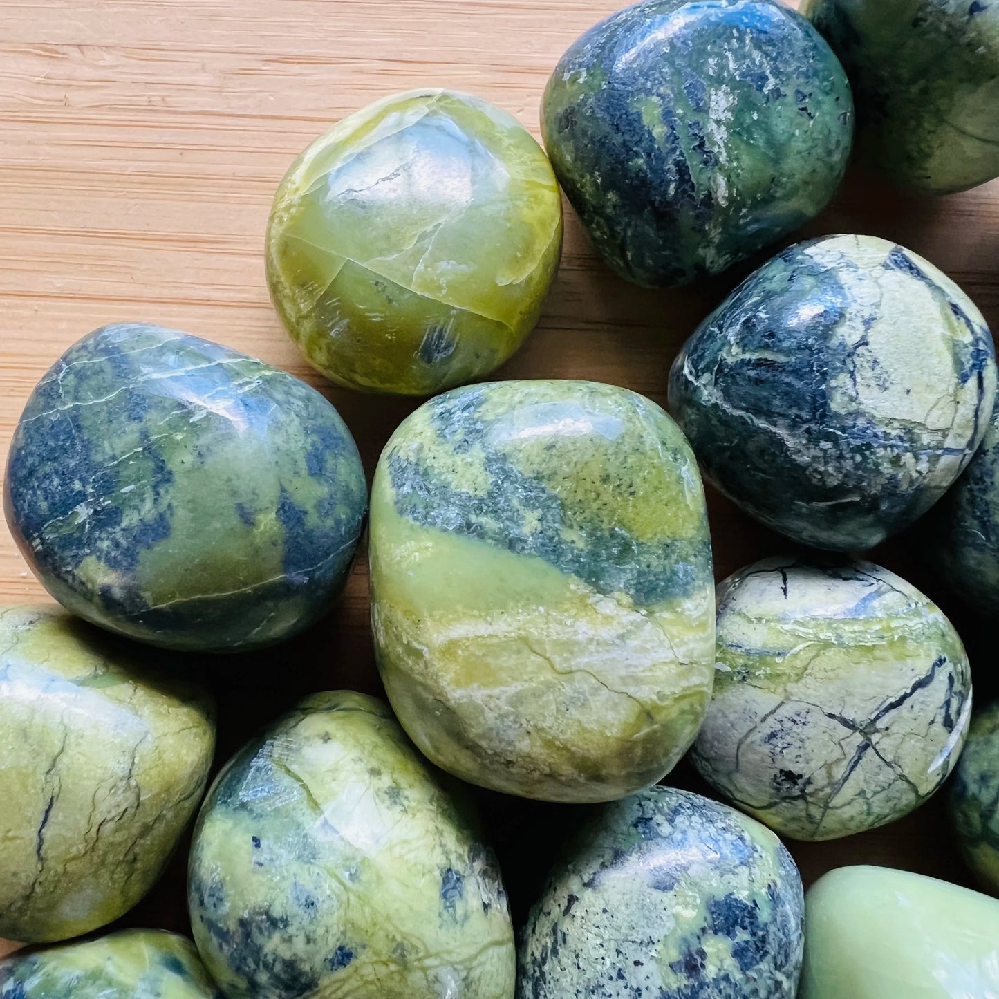 Top-side view of Serpentine tumbled stone, hand-selected from Junín, Peru.