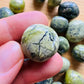 Detail shot of Grade AA Serpentine tumbled stone under natural light
