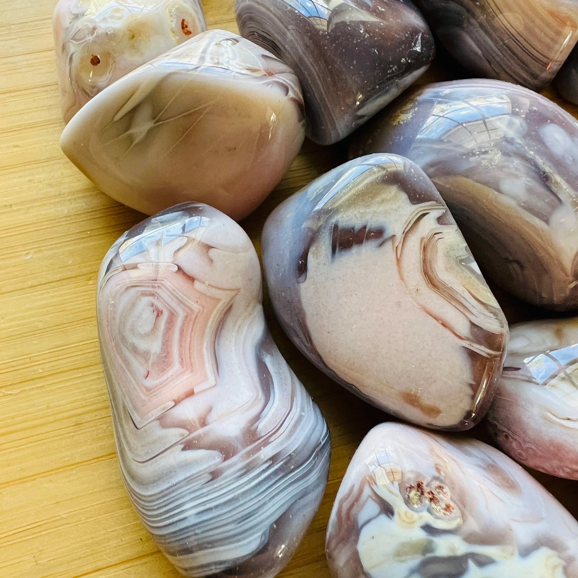 Bottom side of Pink Agate tumbled stone, showing earthy tone.