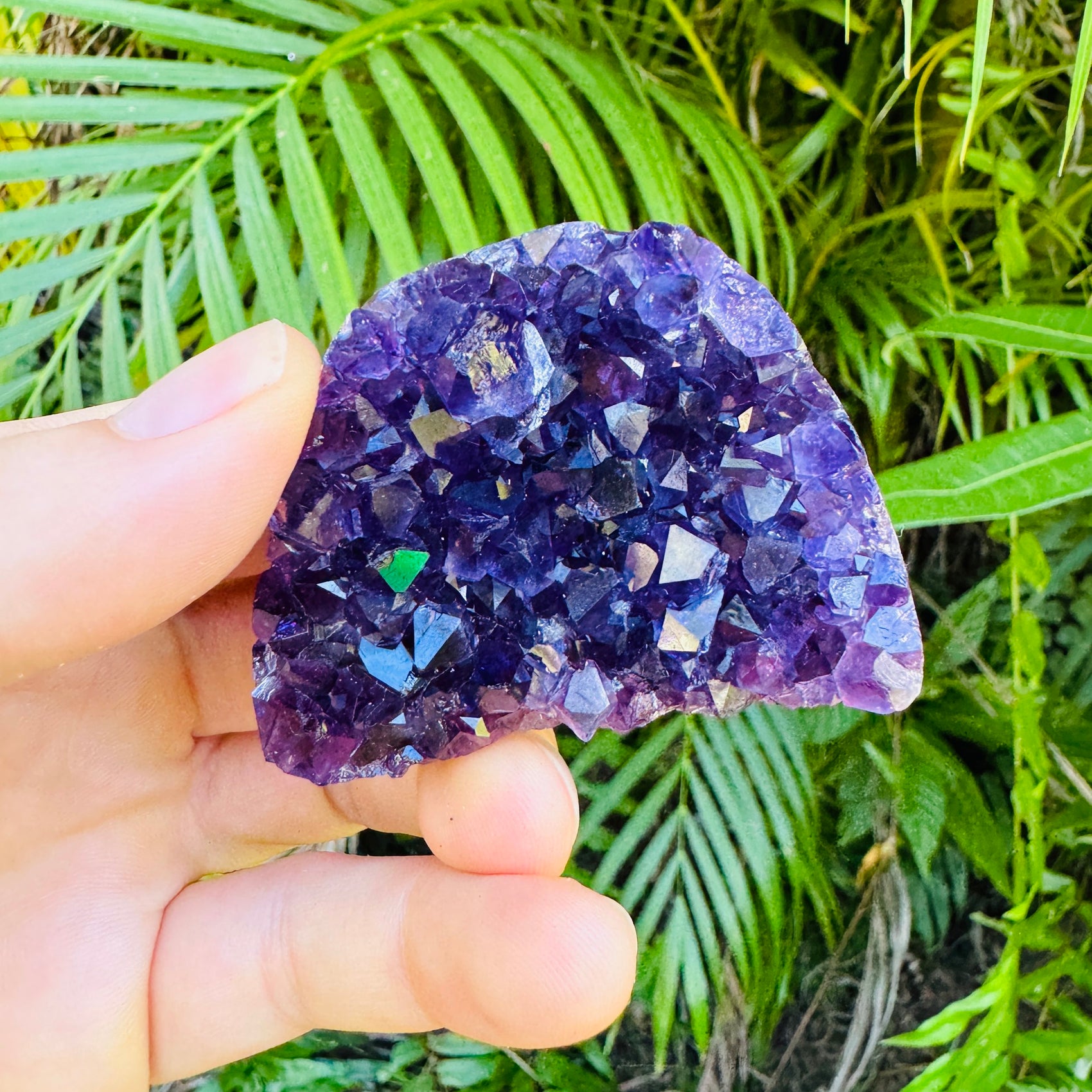 Grade aa amethyst geode held in hand for size reference