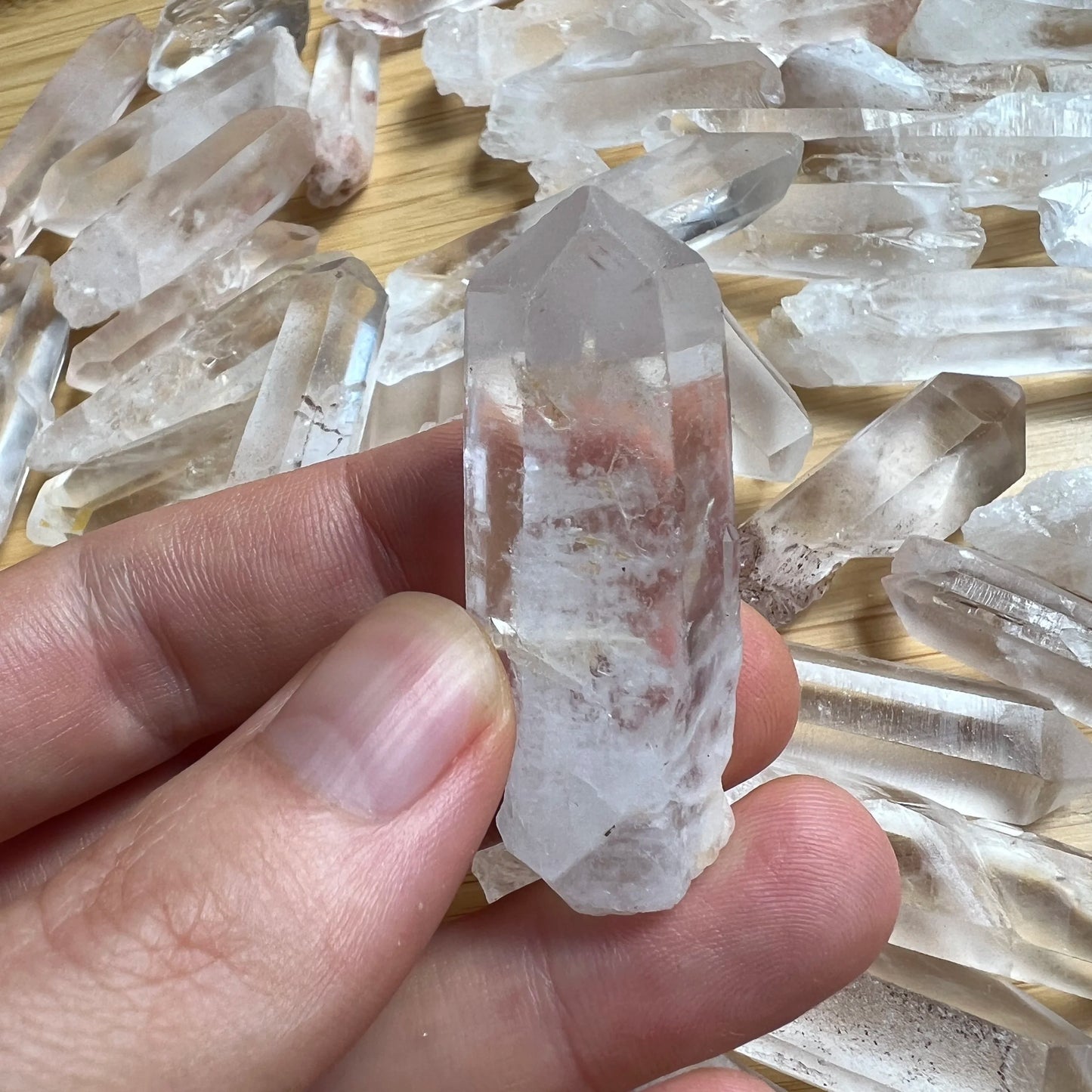Studio-style view of Clear Quartz raw crystal, shown at hand scale.