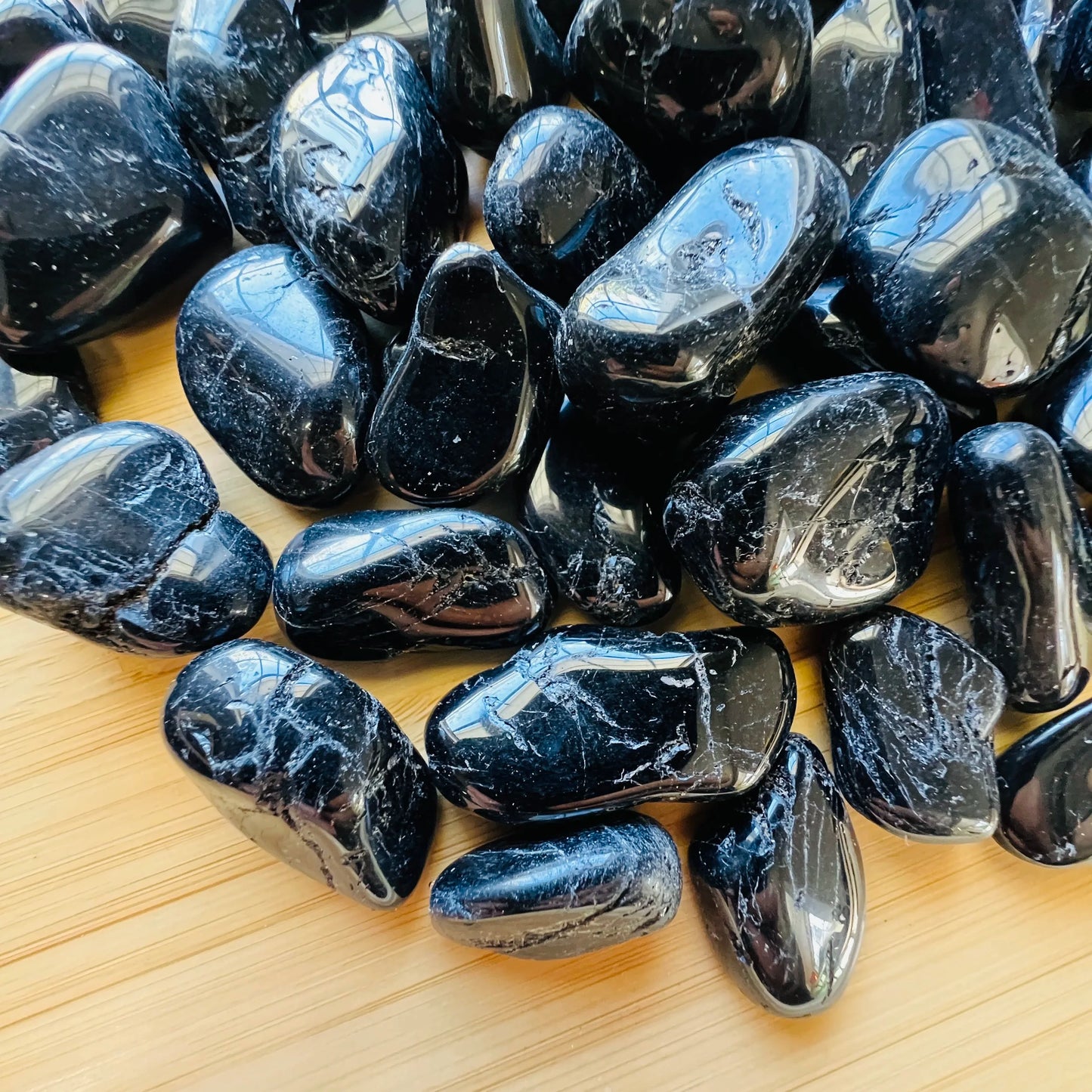 Plan view of Black Tourmaline tumbled stone, showing matte finish, from Minas Gerais, Brazil.