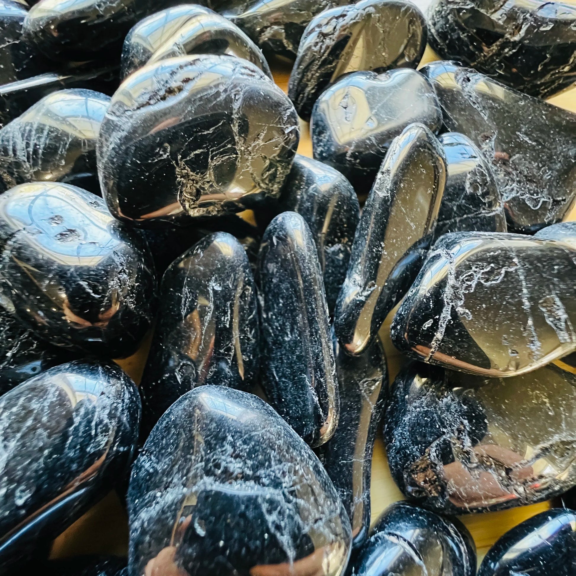 Reverse side of Grade AA Black Tourmaline tumbled stone, hand-selected from Minas Gerais, Brazil, often paired with practices.