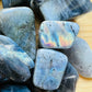 Macro view of Grade AA gray Labradorite tumbled stone, showing soft luster, hand-selected from Atsimo-Andrefana, Madagascar.