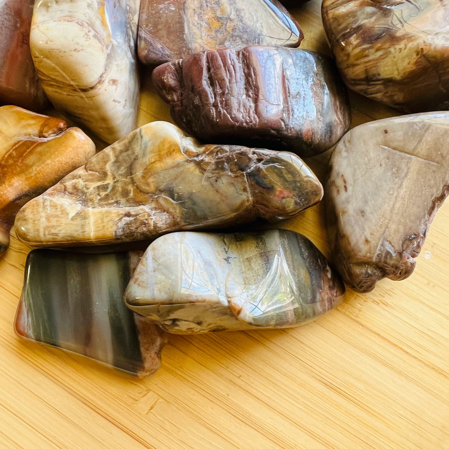 Side profile of Grade A brown Petrified Wood tumbled stone, showing natural sheen, kept near for Grounding.