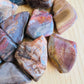 Overhead view of Petrified Wood tumbled stone, showing soft luster, from Boeny, Madagascar.