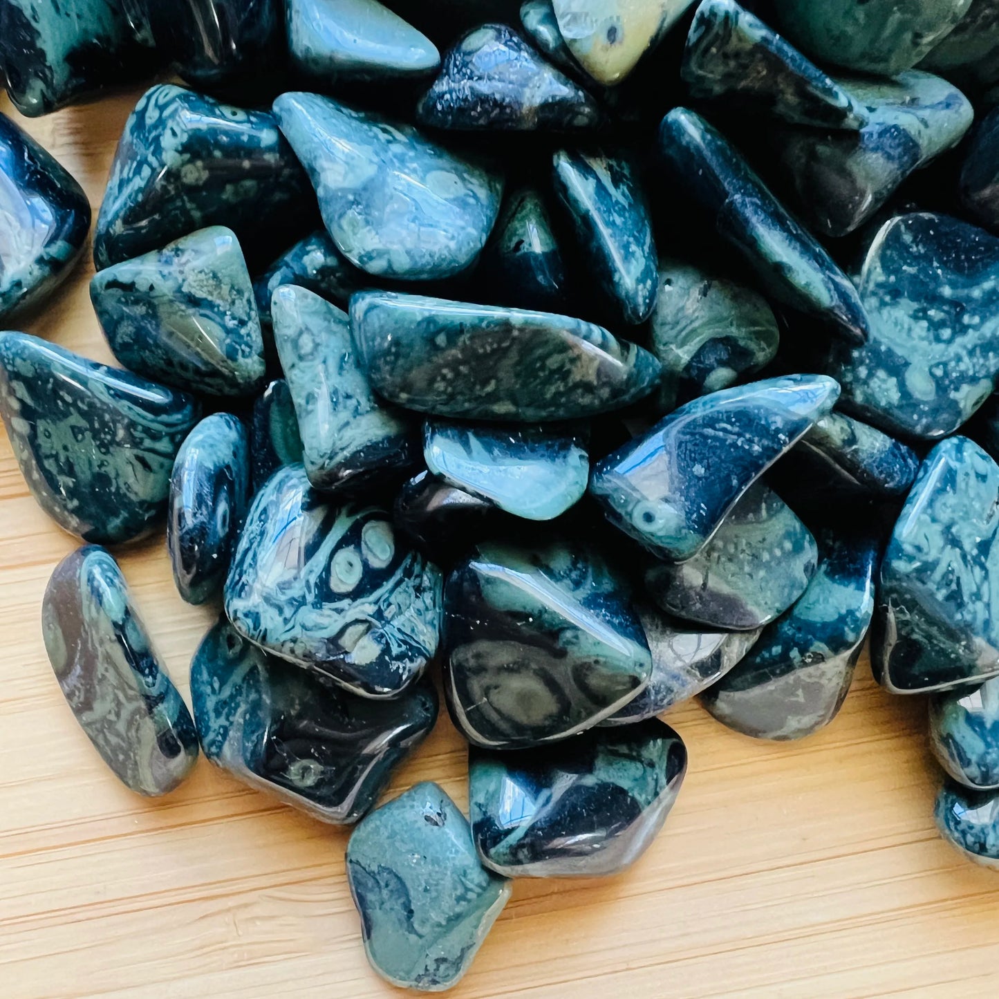 Close-up of Kambaba Jasper tumbled stone, showing natural inclusions, carried for Grounding and Stress Relief.