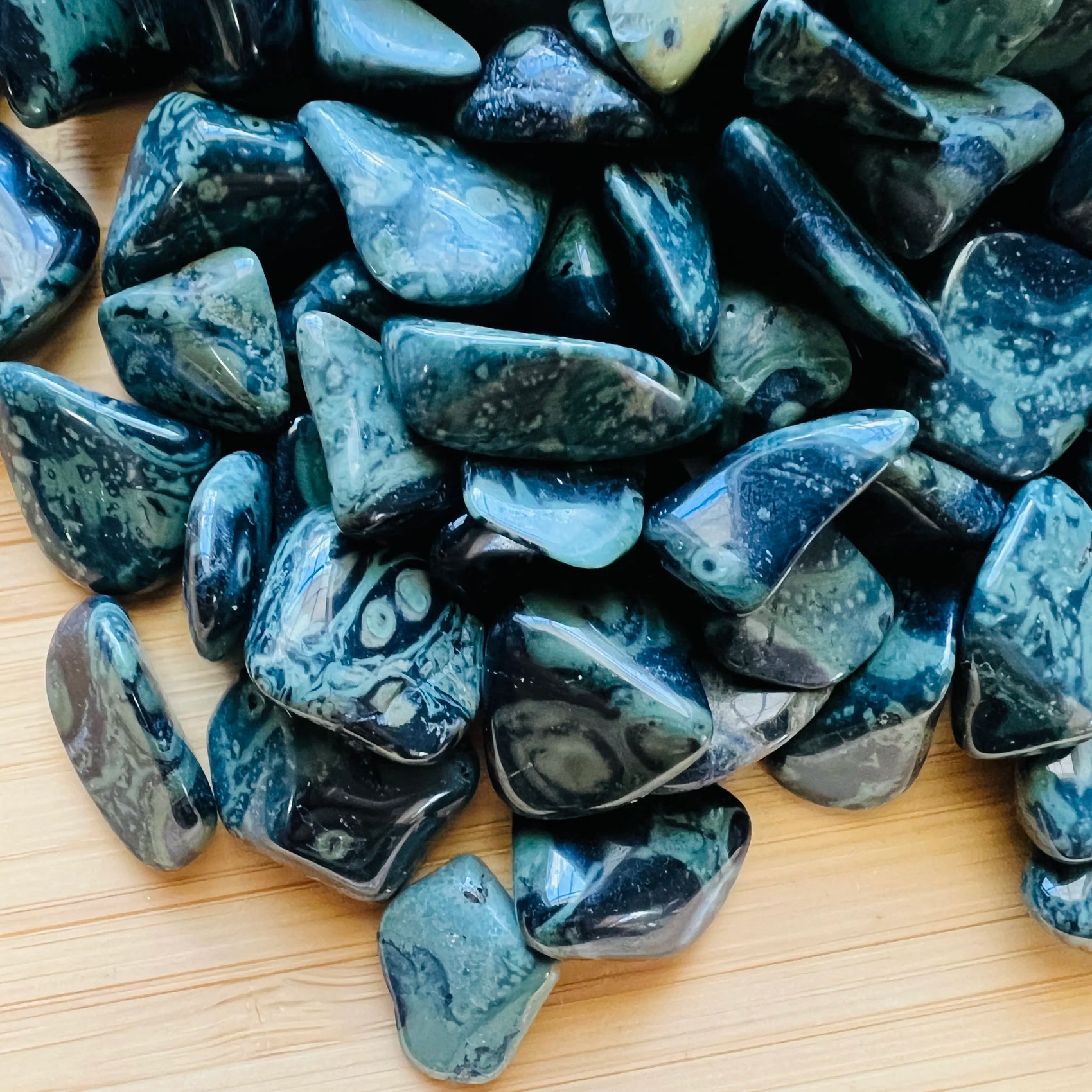 Close-up of Kambaba Jasper tumbled stone, showing natural inclusions, carried for Grounding and Stress Relief.