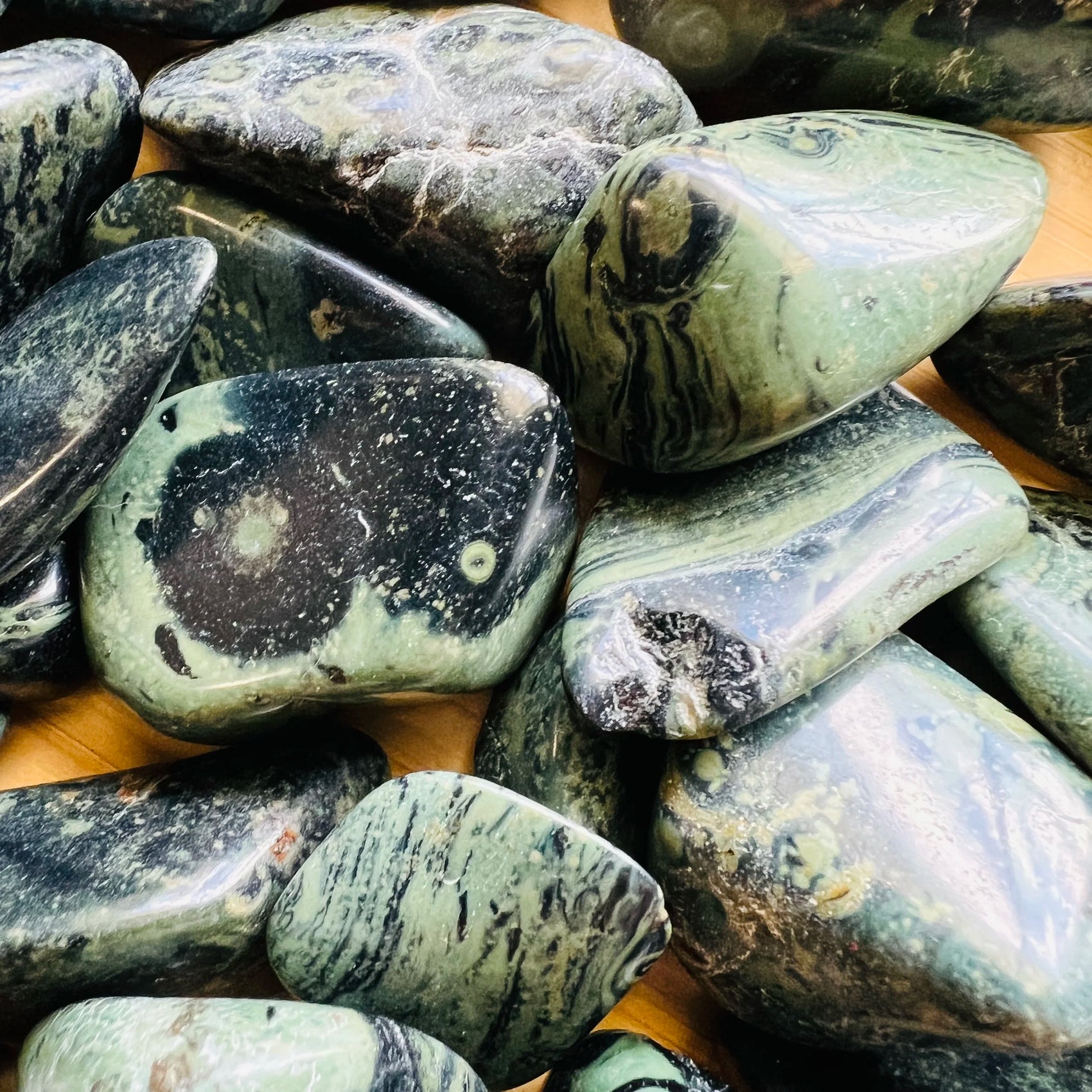 Plan view of Grade AA Kambaba Jasper tumbled stone, showing soft luster.