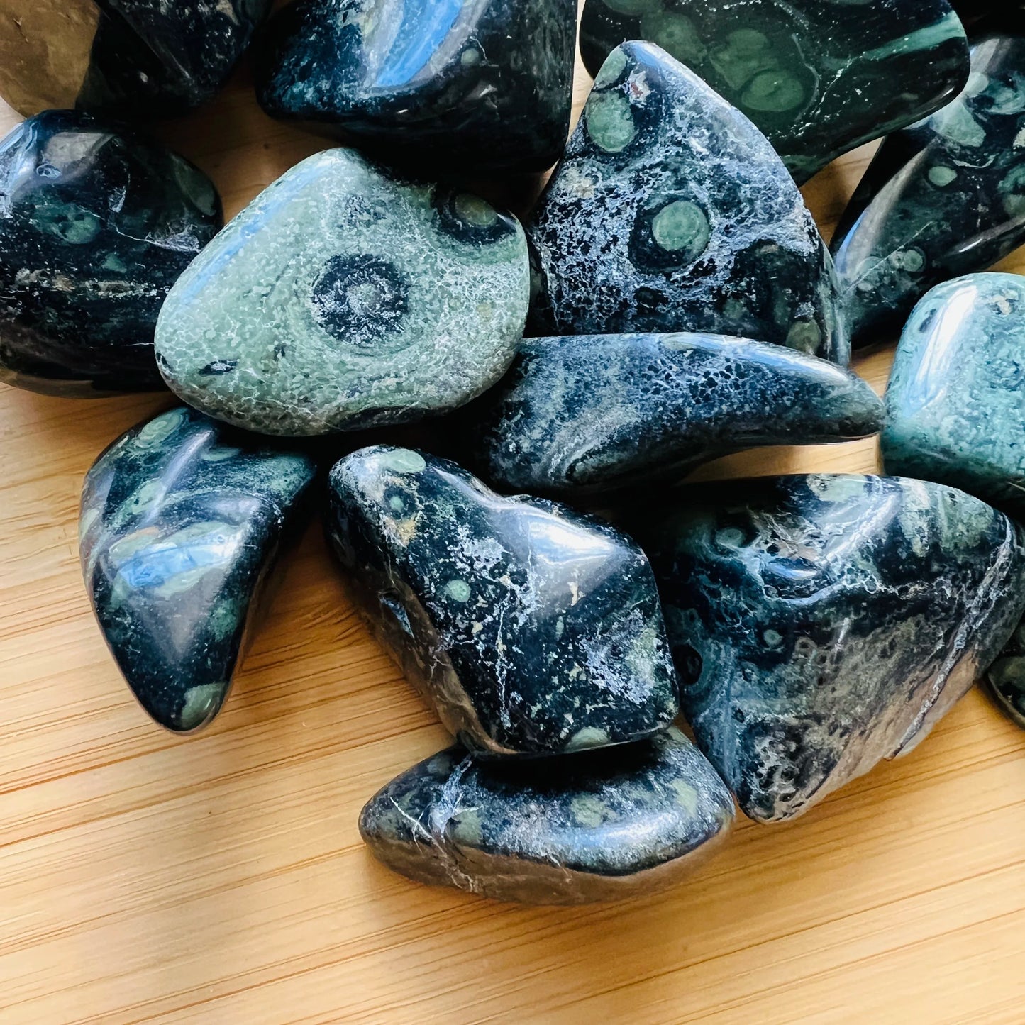 Overhead angle of Grade AA Kambaba Jasper tumbled stone, showing characteristic color, linked to Grounding and Stress Relief.