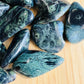 Edge view of Grade AA green Kambaba Jasper tumbled stone, linked to Grounding and Stress Relief.