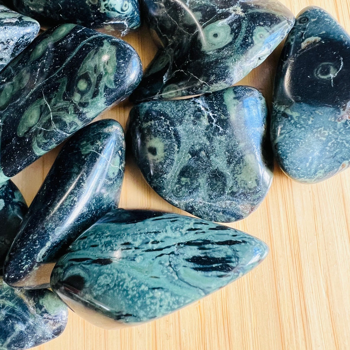 Edge view of Grade AA green Kambaba Jasper tumbled stone, linked to Grounding and Stress Relief.