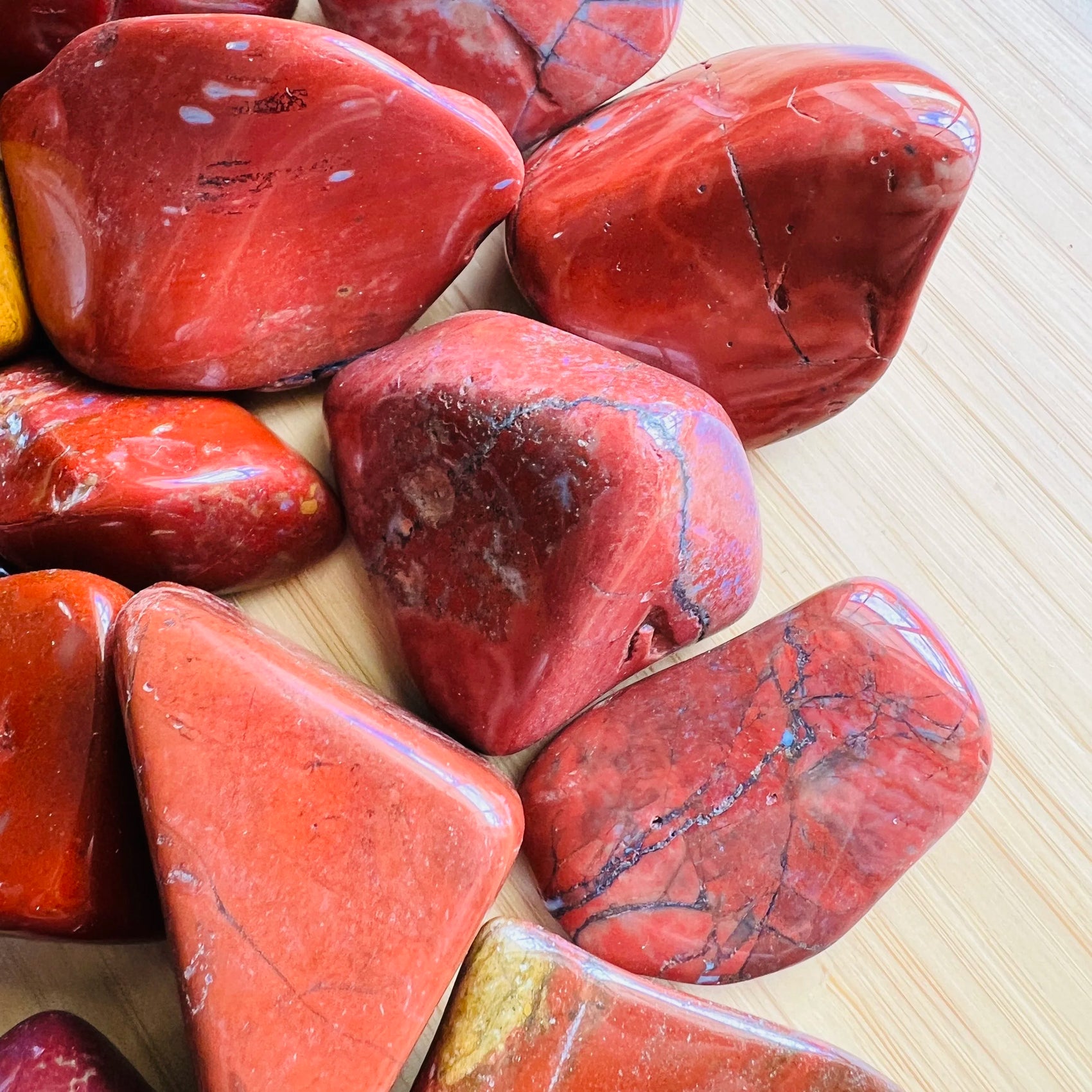 Near view of Red Jasper tumbled stone, showing earthy tone, carried for Grounding.