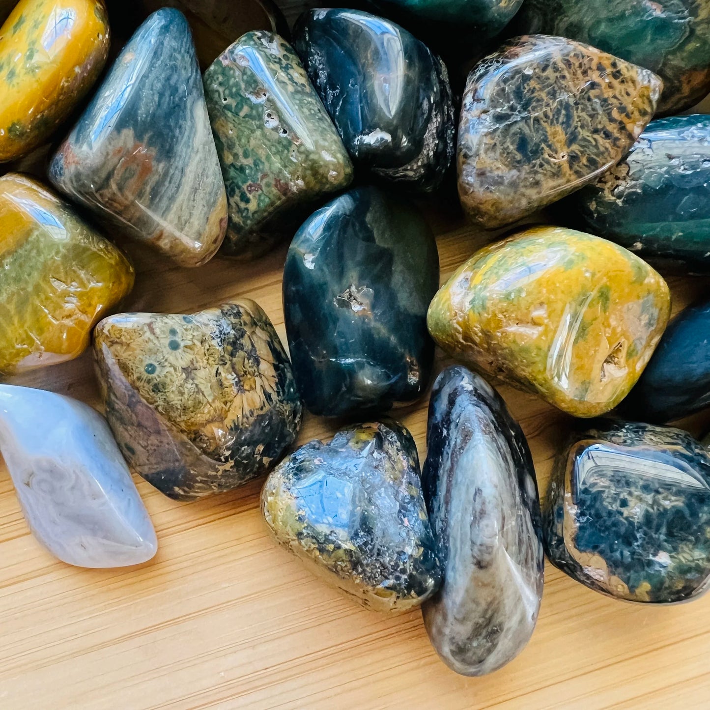 Overhead angle of Grade A green Ocean Jasper tumbled stone, showing soft luster, worked with for Emotional Healing.