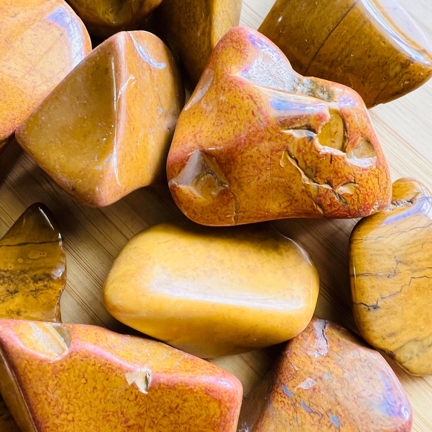 Side angle of Yellow Jasper tumbled stone, showing translucent edges, hand-selected from Sofia, Madagascar.