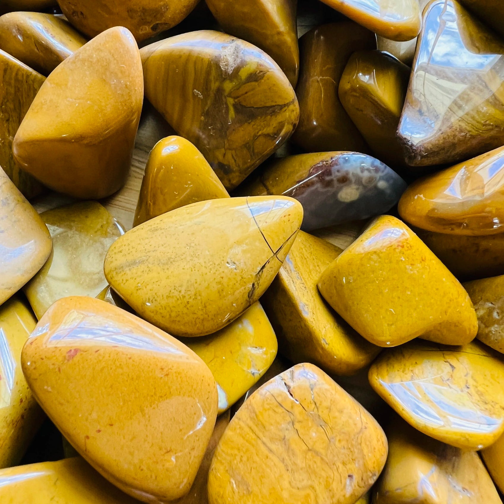 Reverse side of Yellow Jasper tumbled stone, showing translucent edges, sourced from Sofia, Madagascar.