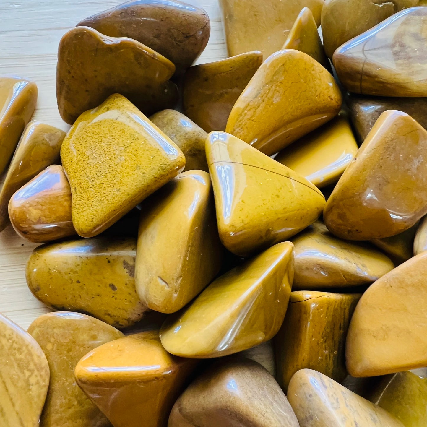 Aerial view of Grade AA Yellow Jasper tumbled stone, showing characteristic color, sourced from Madagascar.