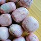 Side profile of Rhodonite tumbled stone, Peru-sourced, often kept for Emotional Healing.