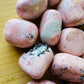 Top angle of Grade AA pink Rhodonite tumbled stone, worked with for Emotional Healing and Love, sourced from Ancash, Peru.