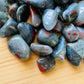 Natural surface of Bloodstone tumbled stone, sourced from Hhohho, Eswatini.