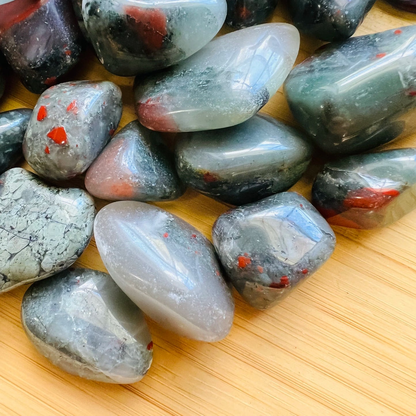 Side-on view of Grade AA Bloodstone tumbled stone, kept near for Energy, sourced from Eswatini.