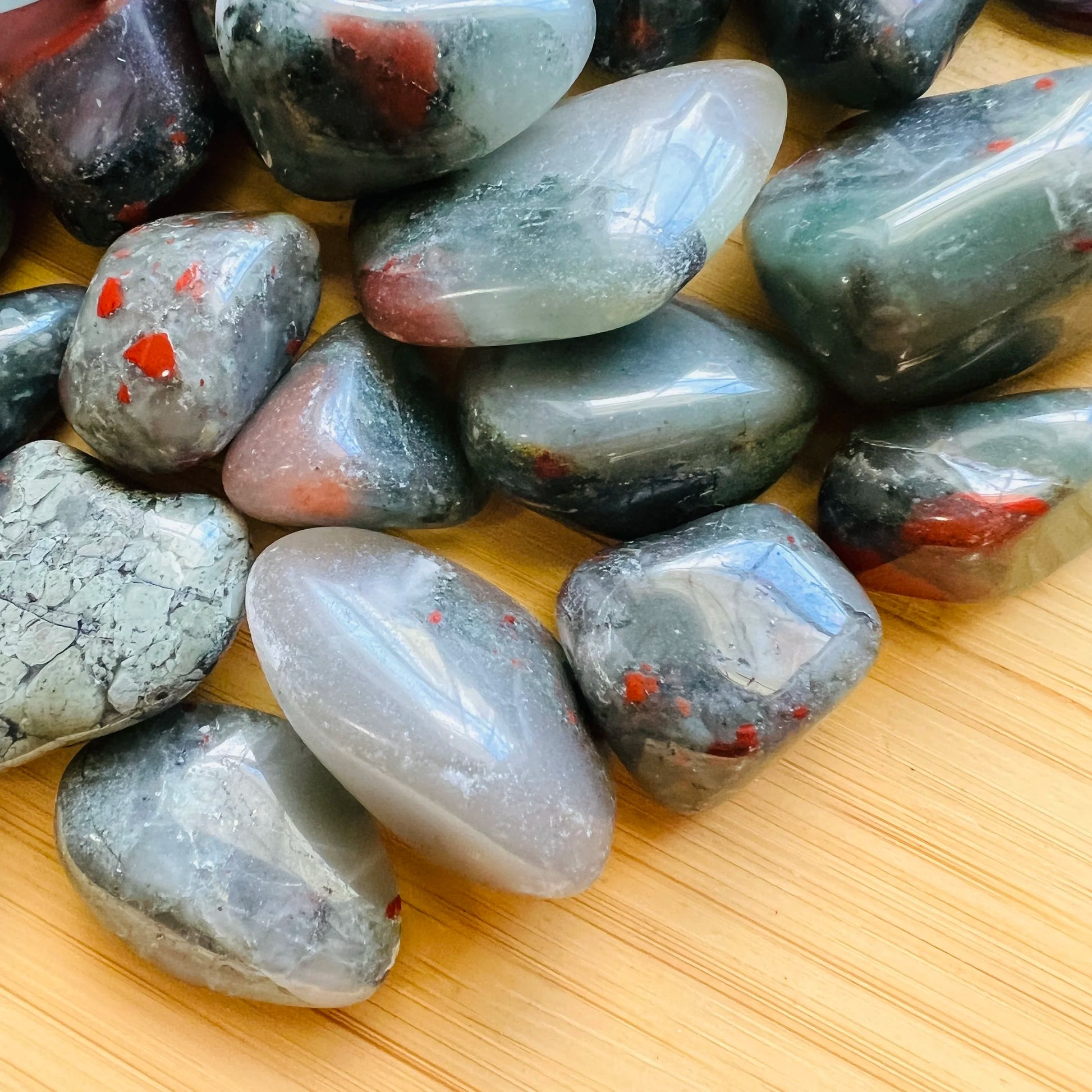 Side-on view of Grade AA Bloodstone tumbled stone, kept near for Energy, sourced from Eswatini.