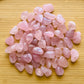 Detail shot of Grade AA Rose Quartz tumbled stone under natural light