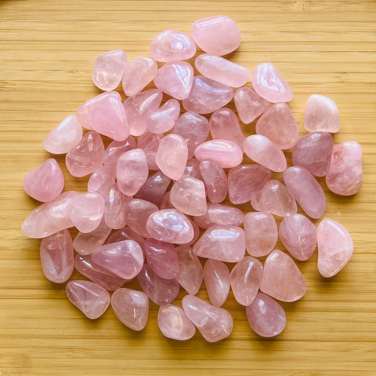 Detail shot of Grade AA Rose Quartz tumbled stone under natural light