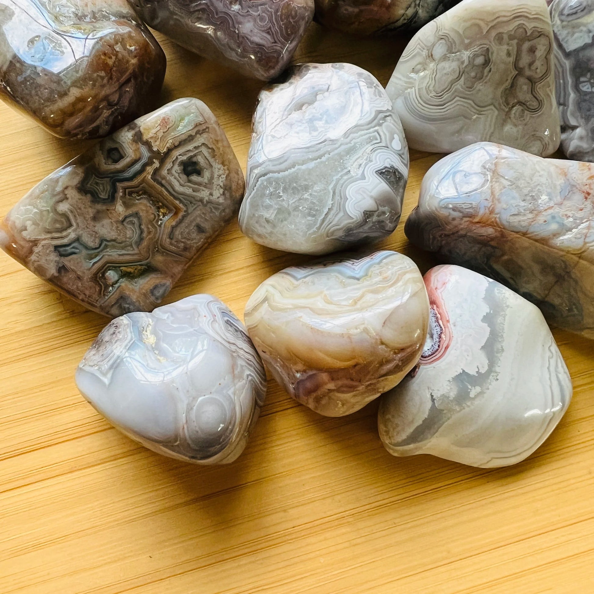 Side profile of Grade A Crazy Lace Agate tumbled stone with natural form and inclusions
