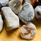 Close-up detail of Grade A Crazy Lace Agate tumbled stone showing natural multicolored tones and texture