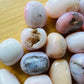 Top-side view of Grade A Pink Opal tumbled stone, from Ica, Peru, showing translucent edges.