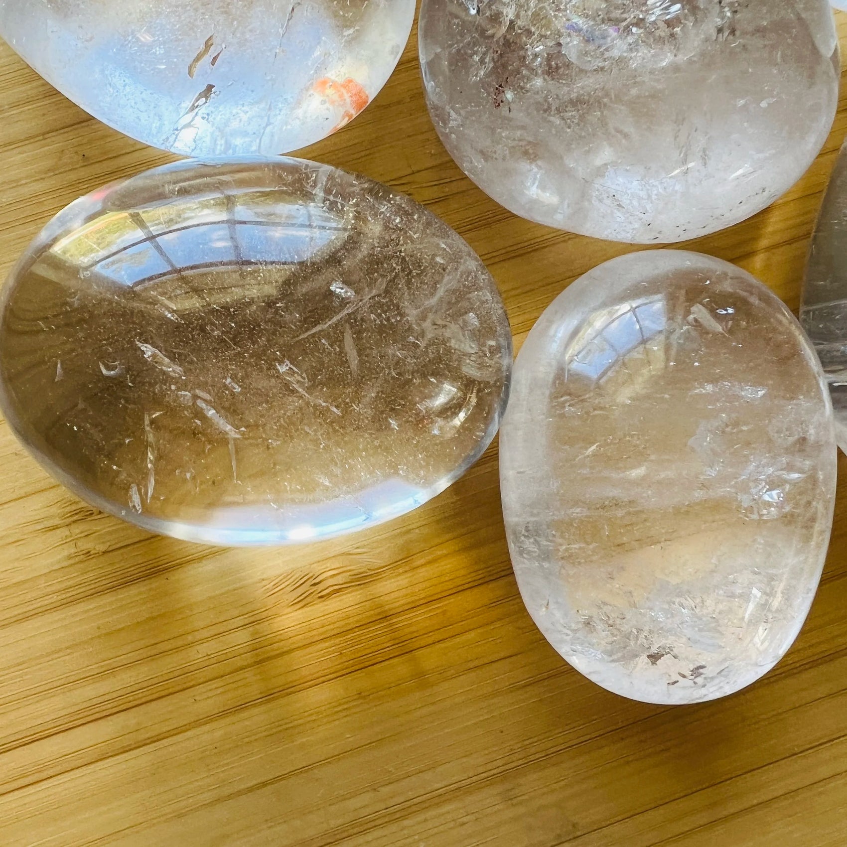 Looking down on Clear Quartz palm stone, from Vakinankaratra, Madagascar, showing natural inclusions.