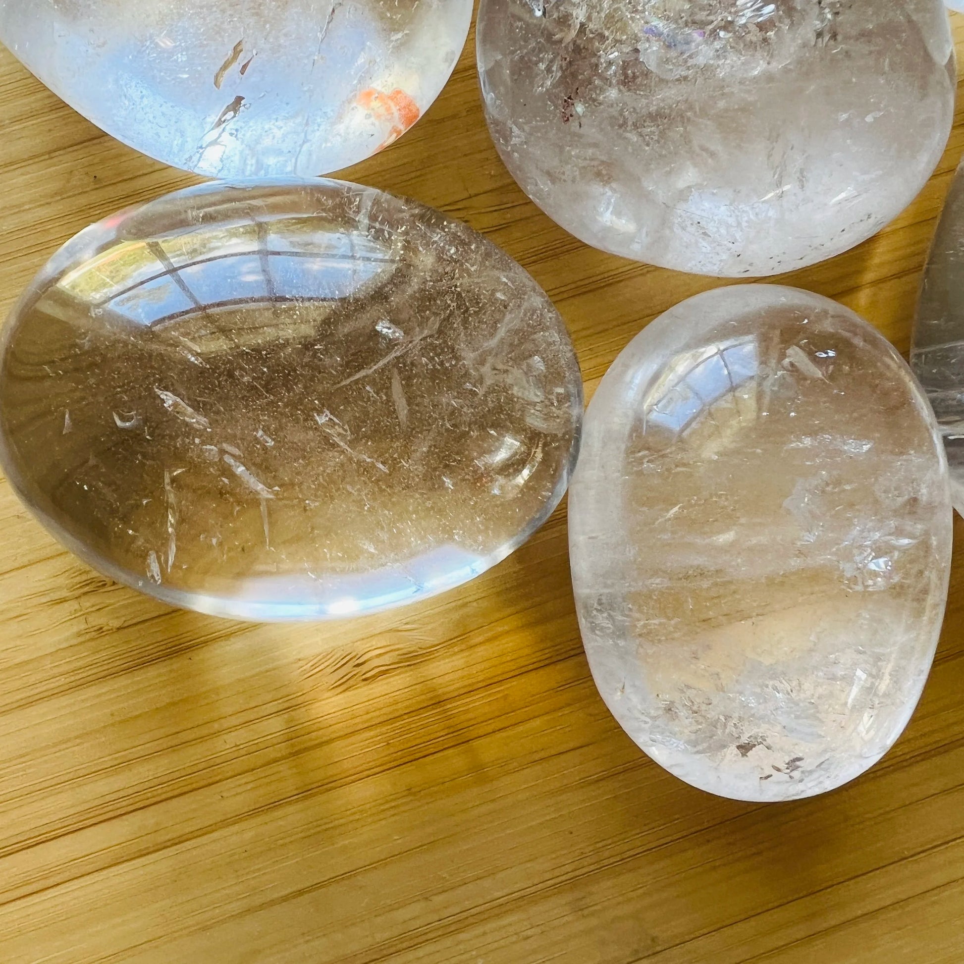 Looking down on Clear Quartz palm stone, from Vakinankaratra, Madagascar, showing natural inclusions.