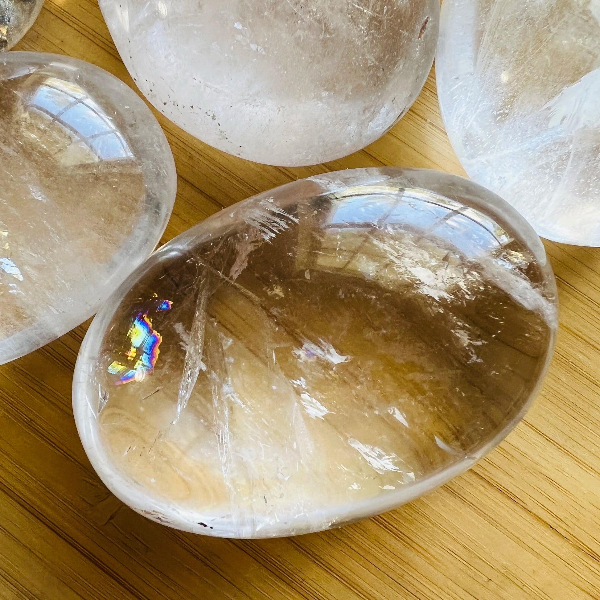 Detail shot showing Grade AA Clear Quartz palm stone, showing subtle veining, hand-selected from Vakinankaratra, Madagascar.
