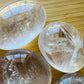 Bottom side of Clear Quartz palm stone, showing subtle veining, traditionally used for Cleansing and Meditation.