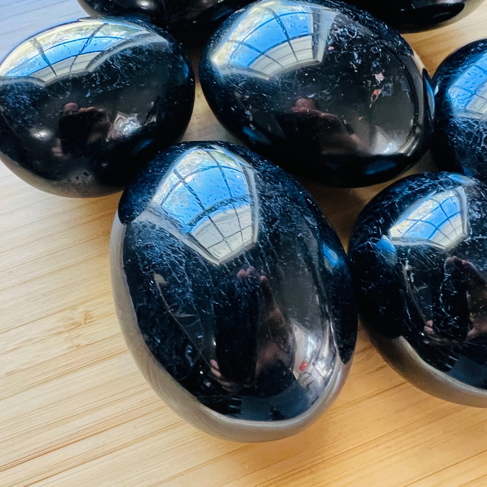 Edge-on view of Black Tourmaline palm stone, showing characteristic color.