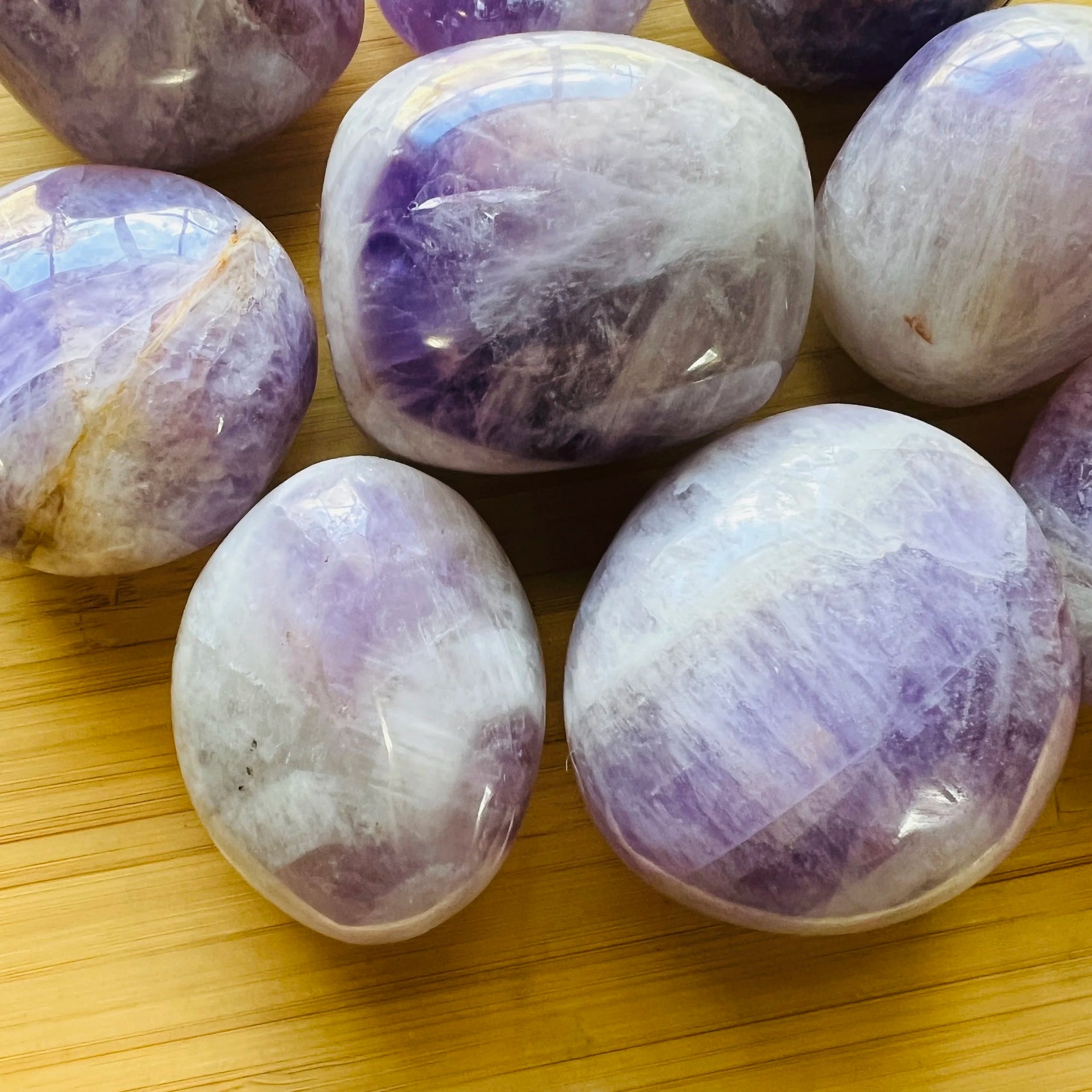 Daylight view of a Banded Amethyst palm stone held against natural backdrop.