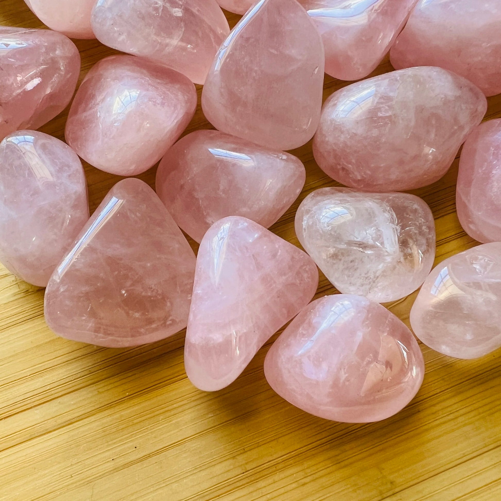 Side profile of Grade AA Rose Quartz tumbled stone with natural form and inclusions