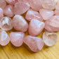 Close-up detail of Grade AA Rose Quartz tumbled stone showing natural pink tones and texture