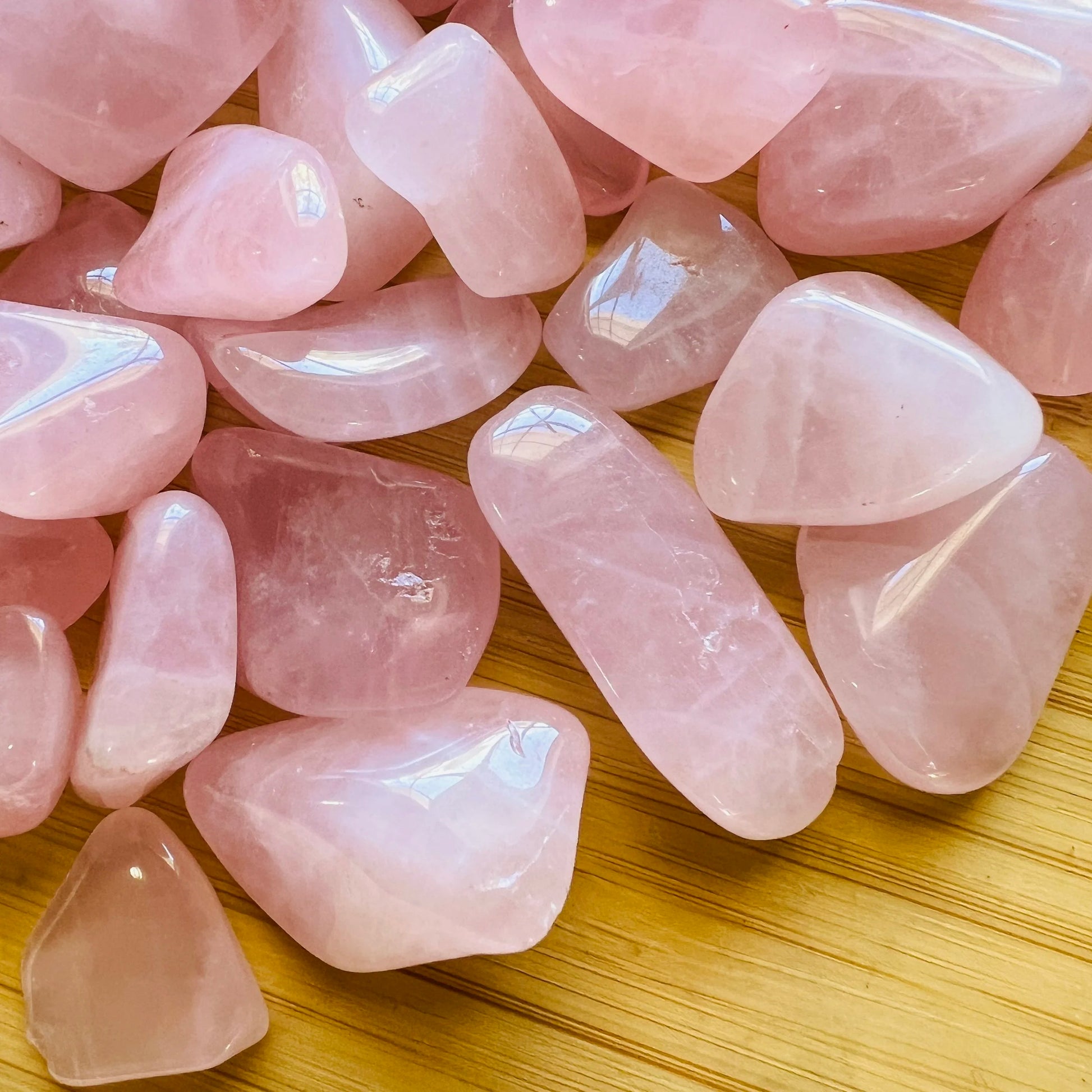 Side angle of Rose Quartz tumbled stone, drawn on for Love, sourced from Madagascar.