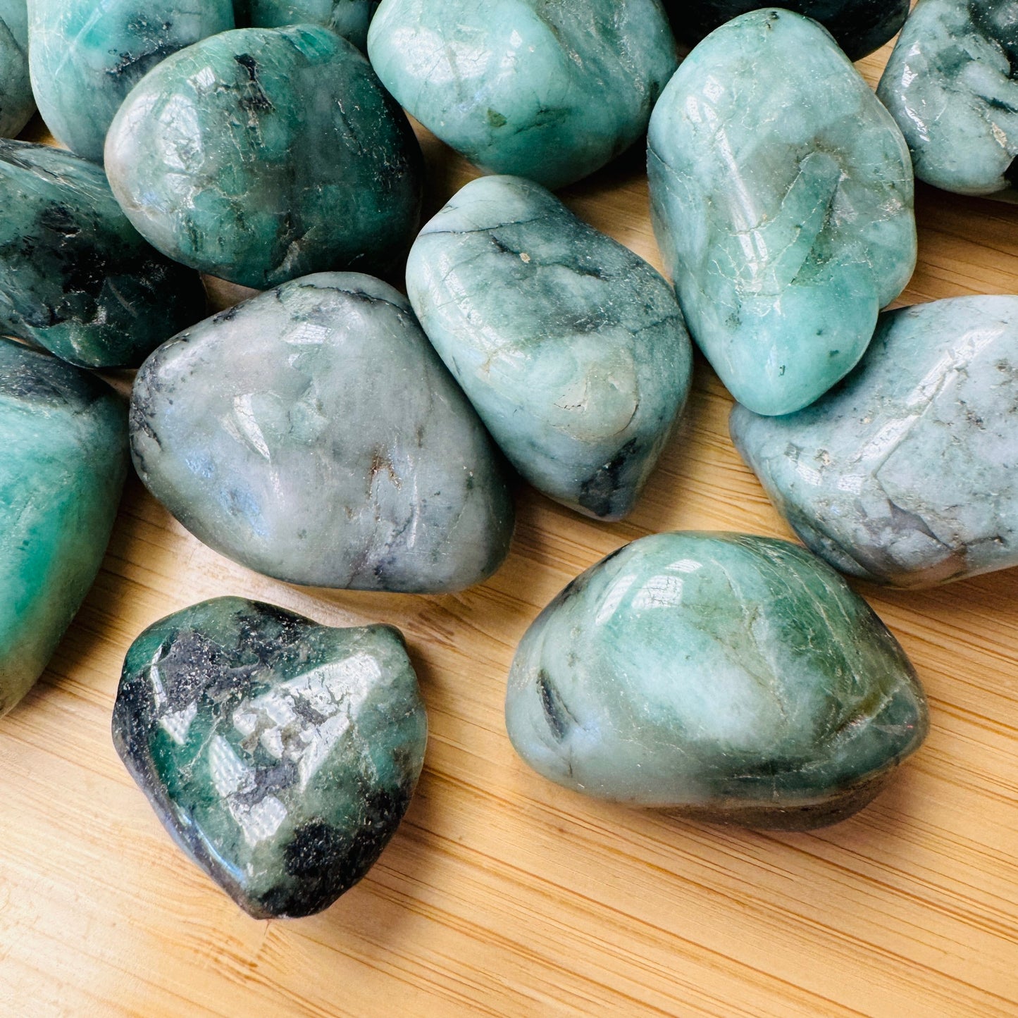 Side perspective of Emerald tumbled stone, sourced from Brazil, showing soft luster.