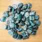 Back view of Grade AA Emerald tumbled stone showing natural surface