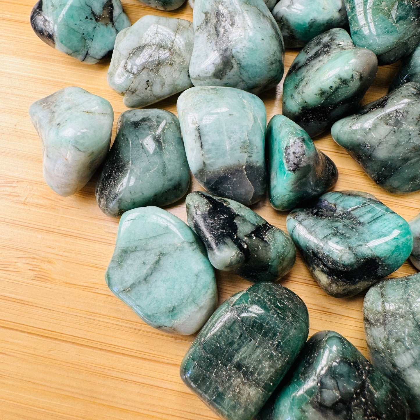 Detail shot of Grade AA Emerald tumbled stone under natural light