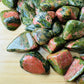 Profile shot of Unakite tumbled stone, kept close for Emotional Healing, showing natural variation.