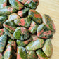 Bottom side of Unakite tumbled stone, showing natural inclusions.