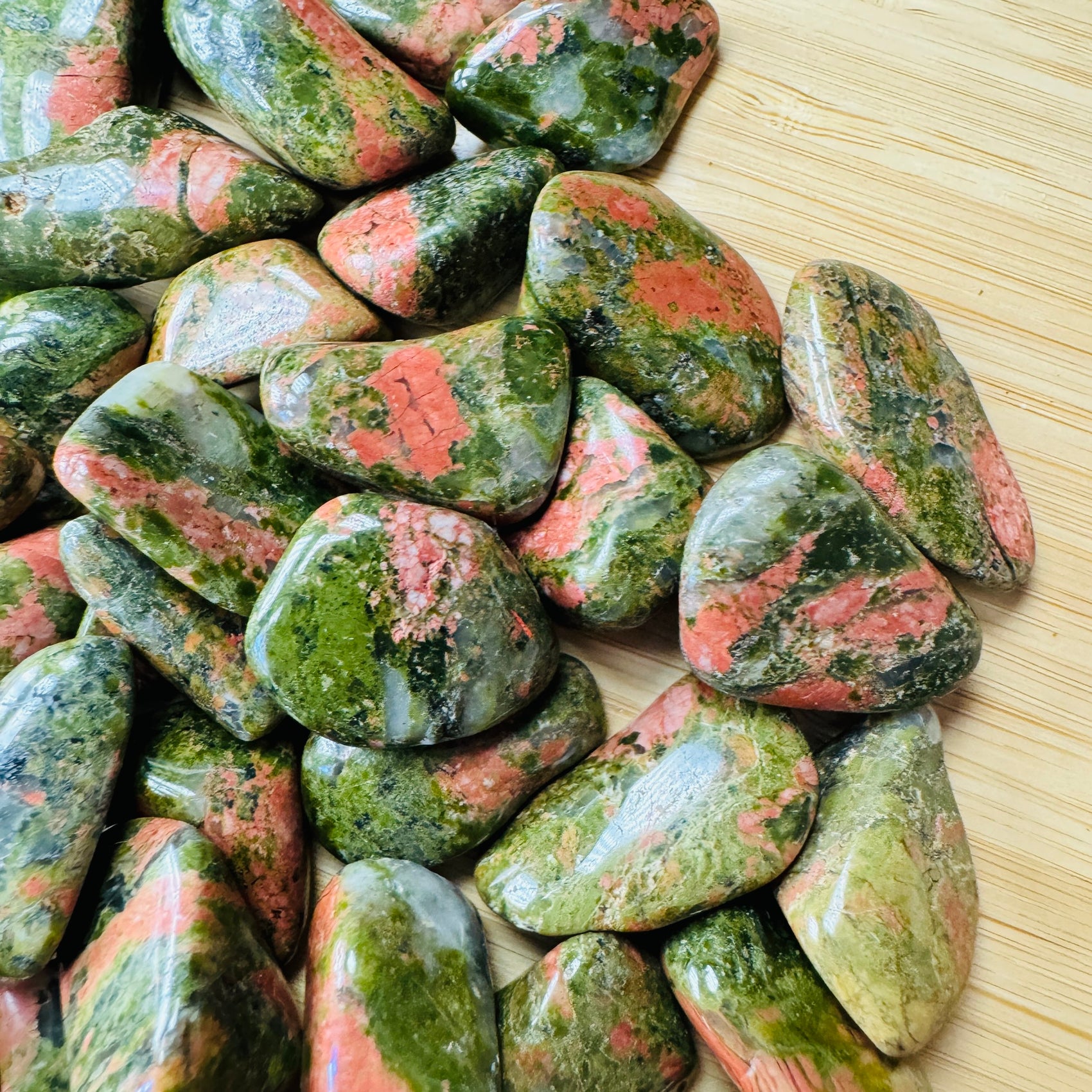 Bottom side of Unakite tumbled stone, showing natural inclusions.