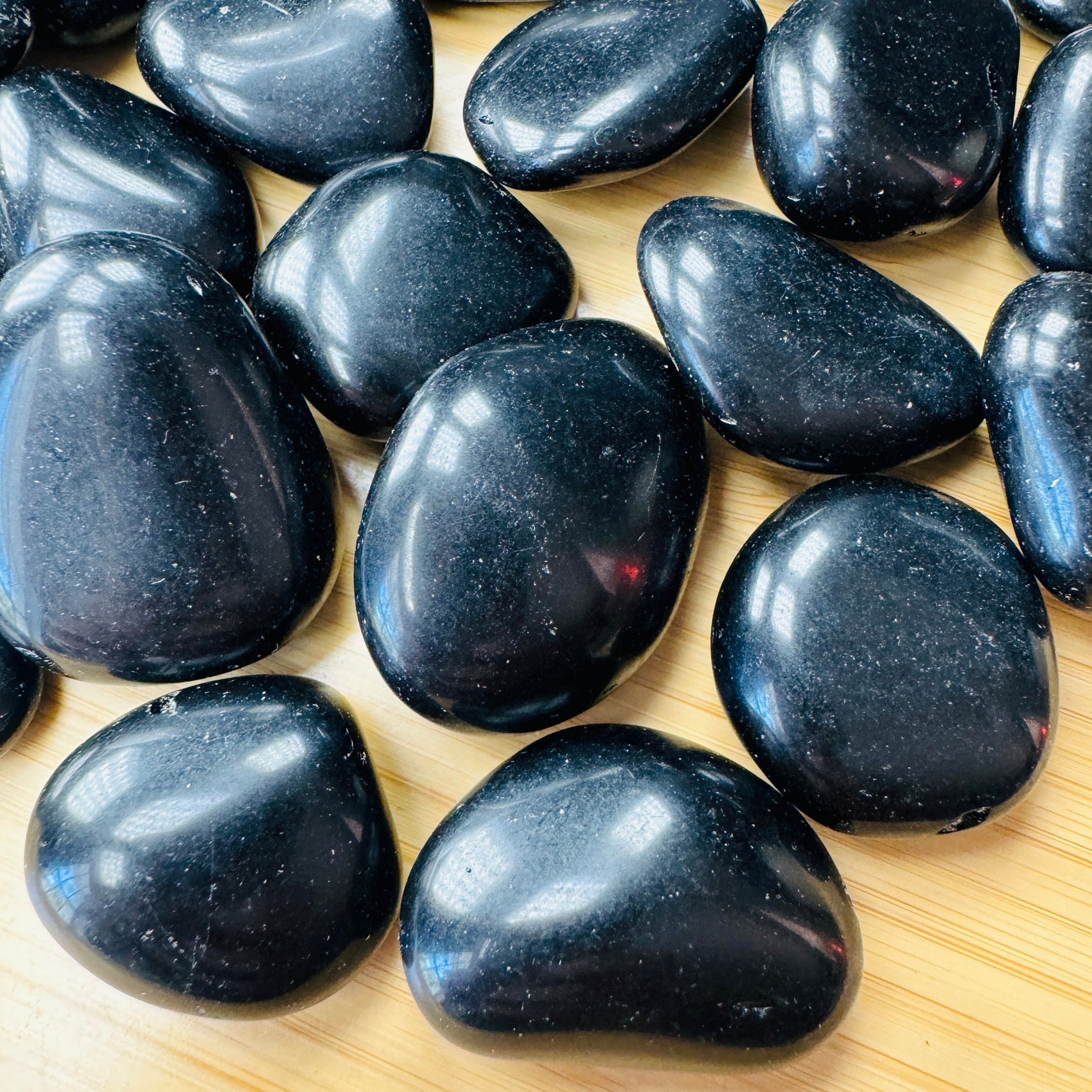Close-up of Black Obsidian tumbled stone from Argentina, soothing wellness stone for Emotional Healing
