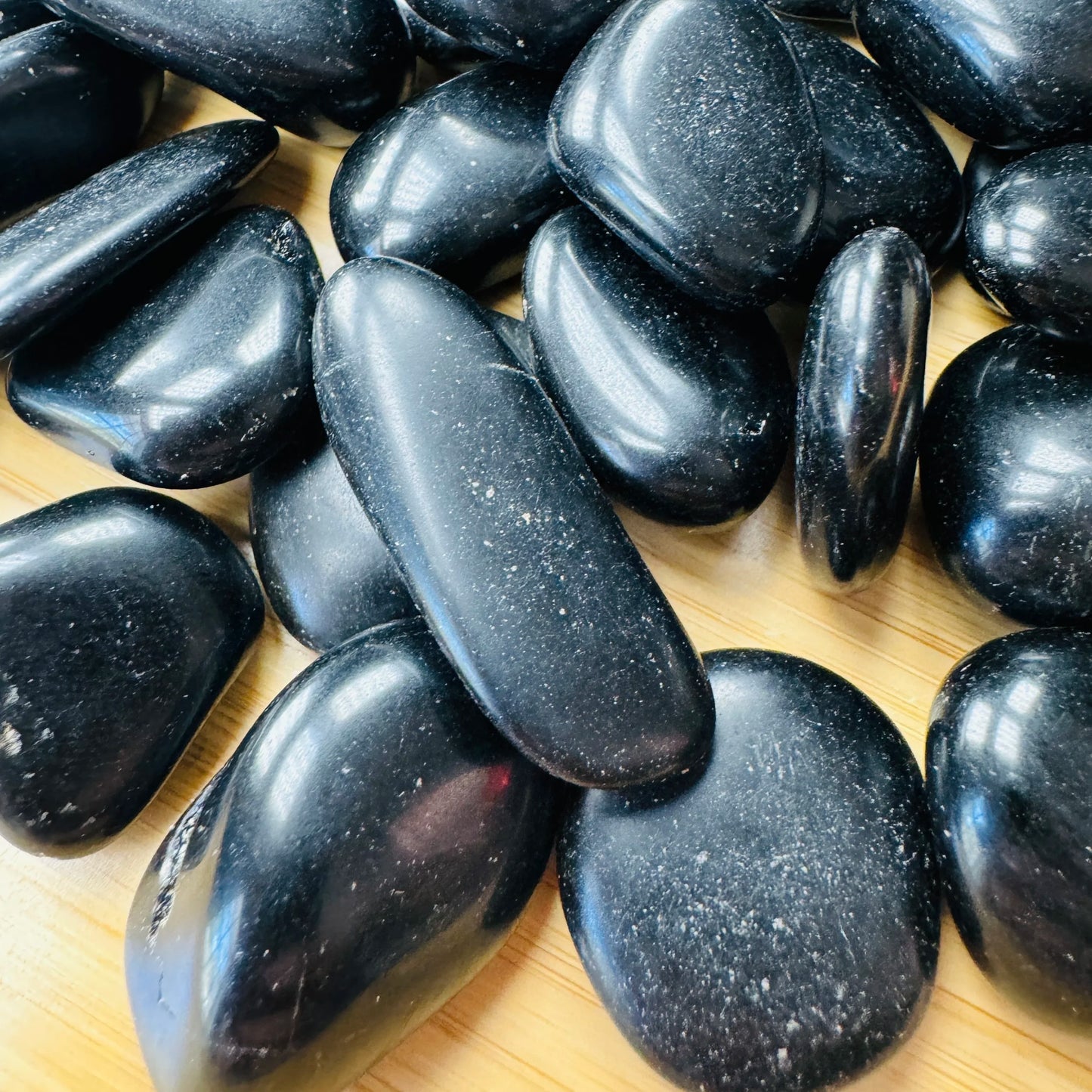 Macro view of Black Obsidian tumbled stone, showing natural sheen.